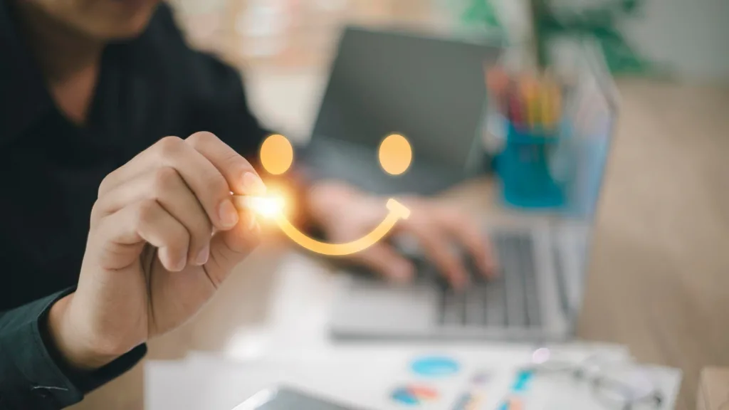 Testimonials play a crucial role so this picture of two hands in a blurred background tells they are happy with our service. the hand is drawing a smiley face on the screen